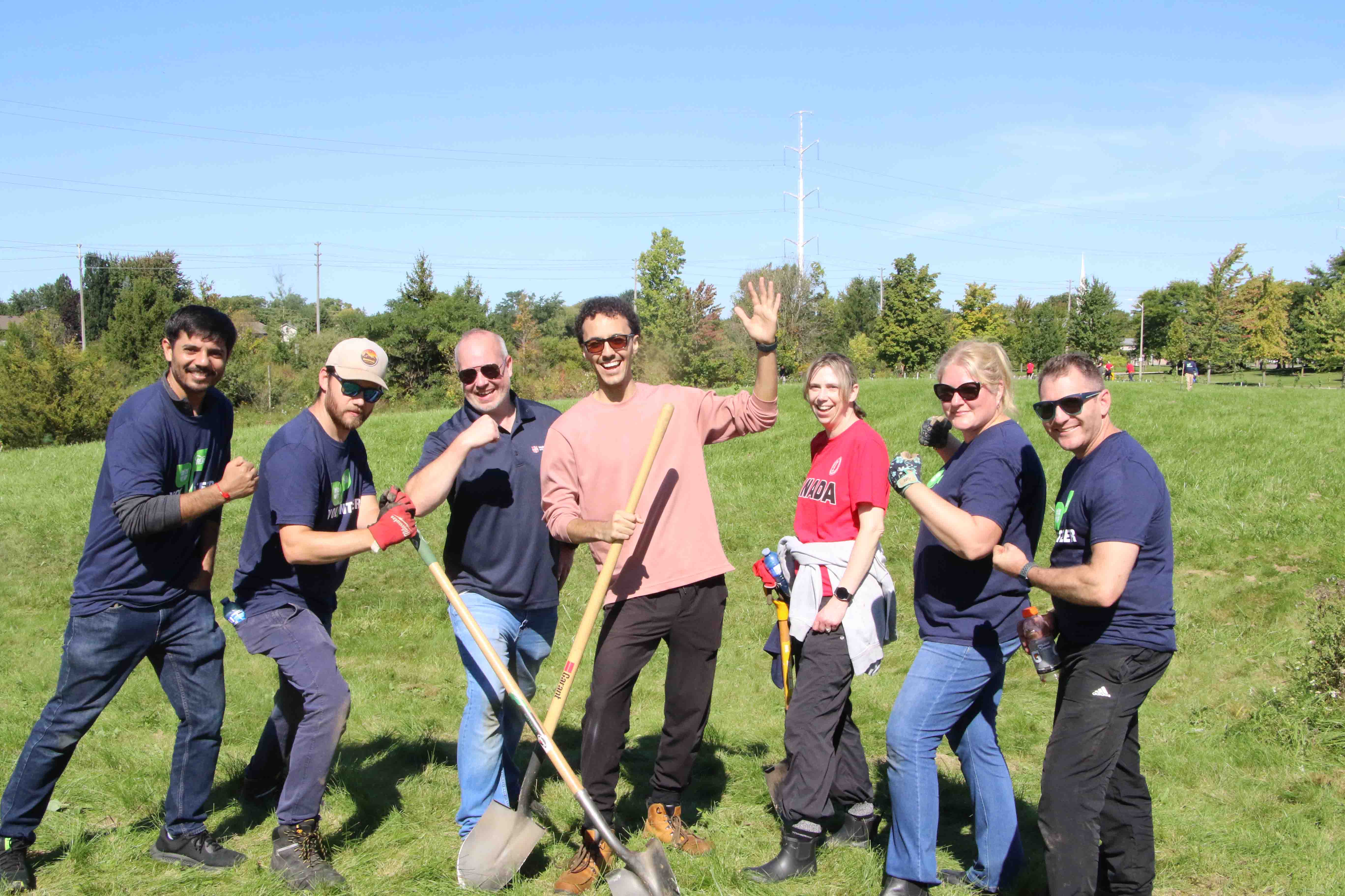 Group of people holding shovels and wearing gloves